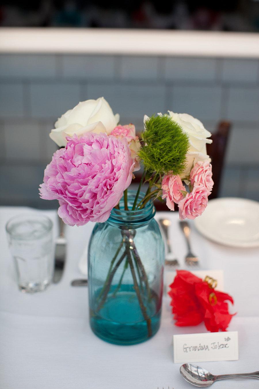 floral centerpiece in blue glass jar